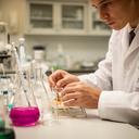Profesional de química revisando fórmulas en un laboratorio de control de calidad